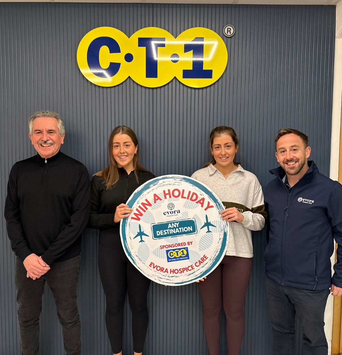 Evora Hospice fundraisers with CT1 sponsor holding a “Win a Holiday” £5,000 raffle sign